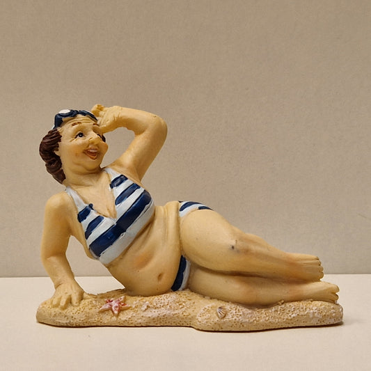 Eldre badedame på stranden, liggende