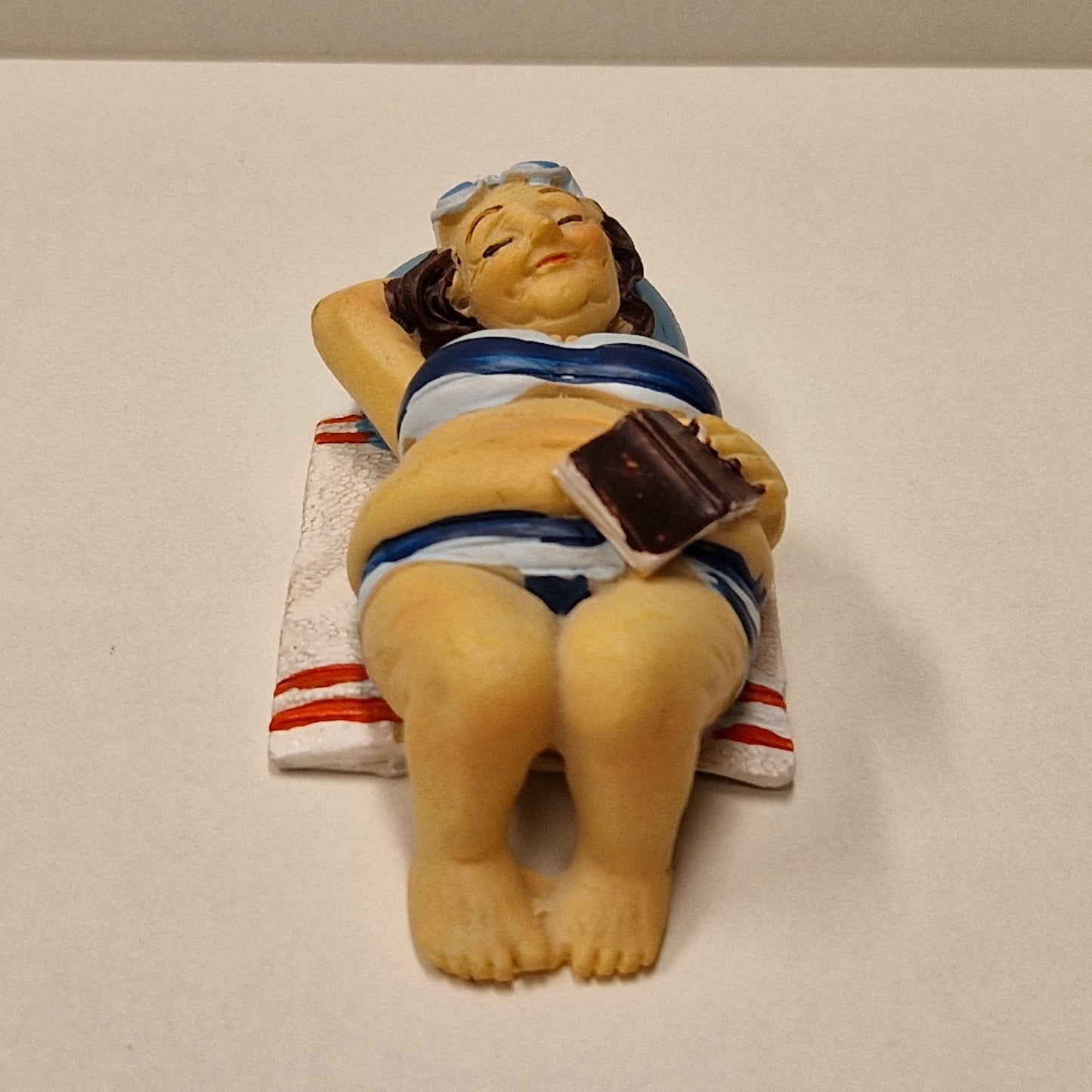 Eldre badedame på håndkle, liggende