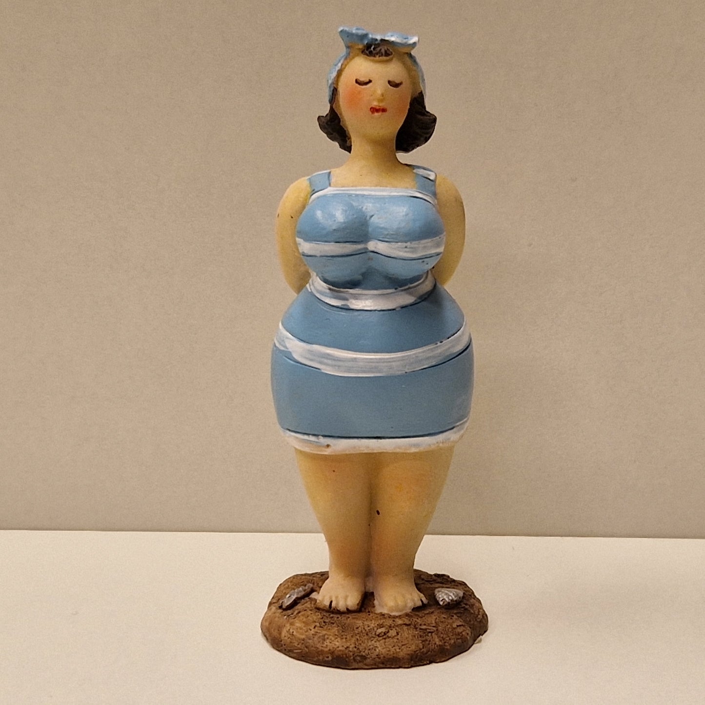 Lubben dame i stripete badedrakt og hårbånd, lys blå