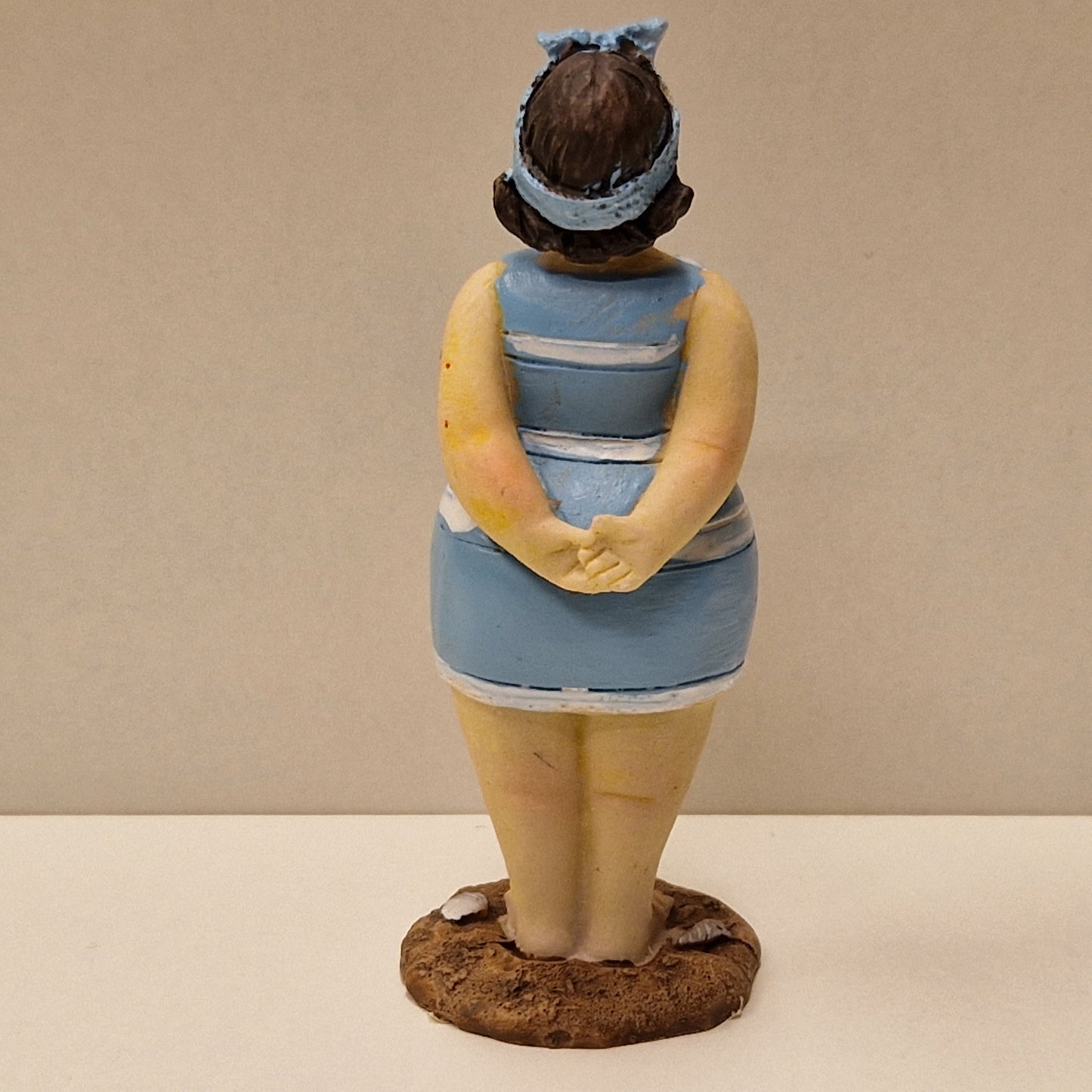 Lubben dame i stripete badedrakt og hårbånd, lys blå