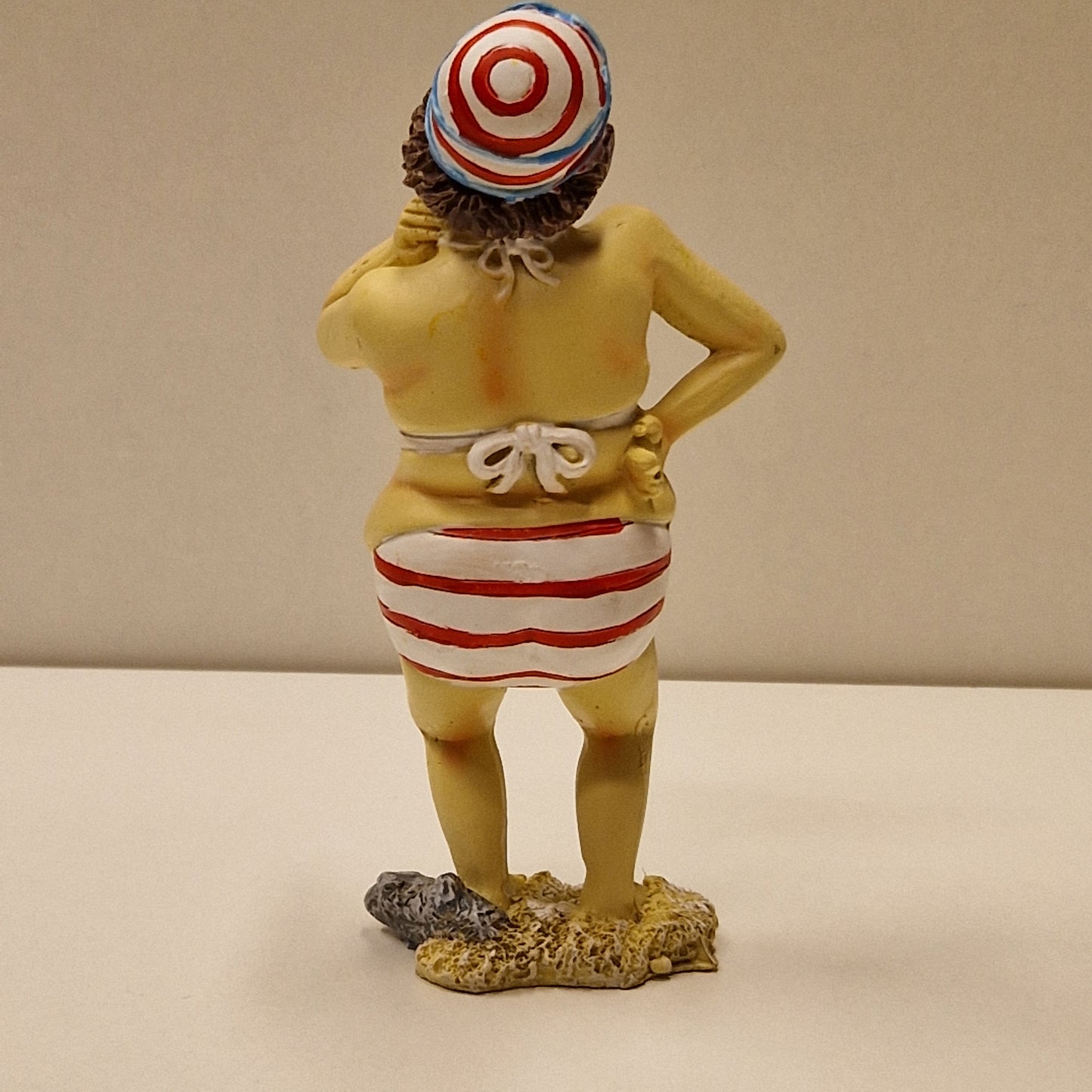 Sjarmerende eldre badedame i bikini med bedårende blikk