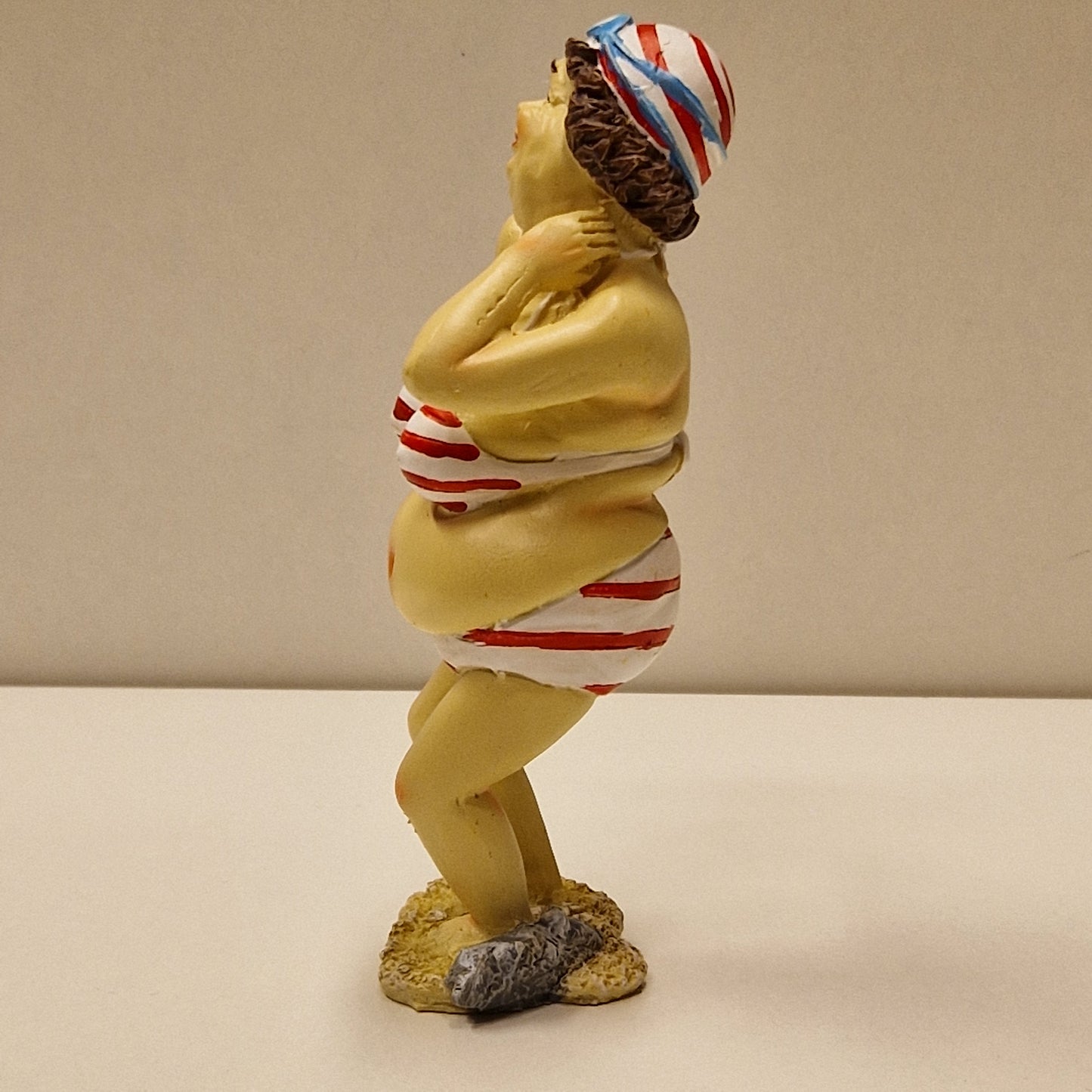 Sjarmerende eldre badedame i bikini med bedårende blikk