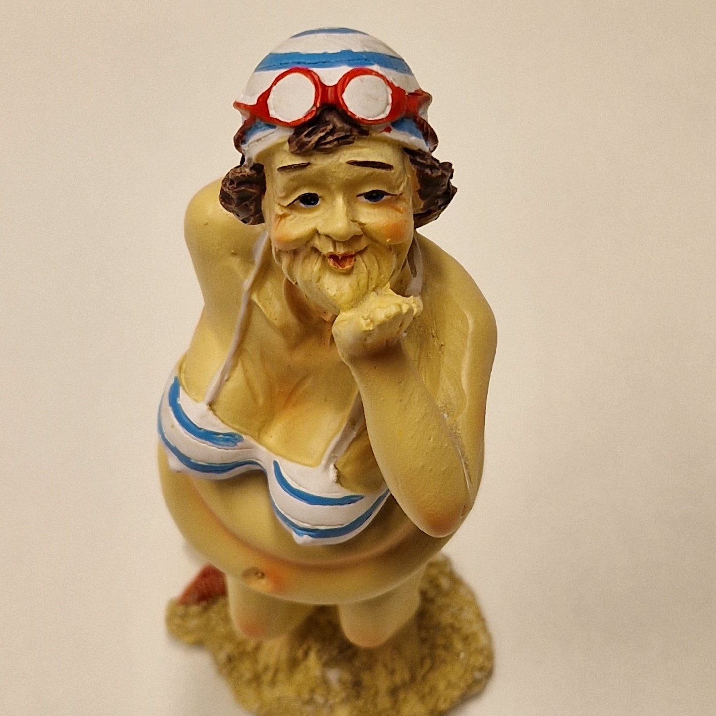 Sjarmerende eldre badedame i bikini som sender slengkyss