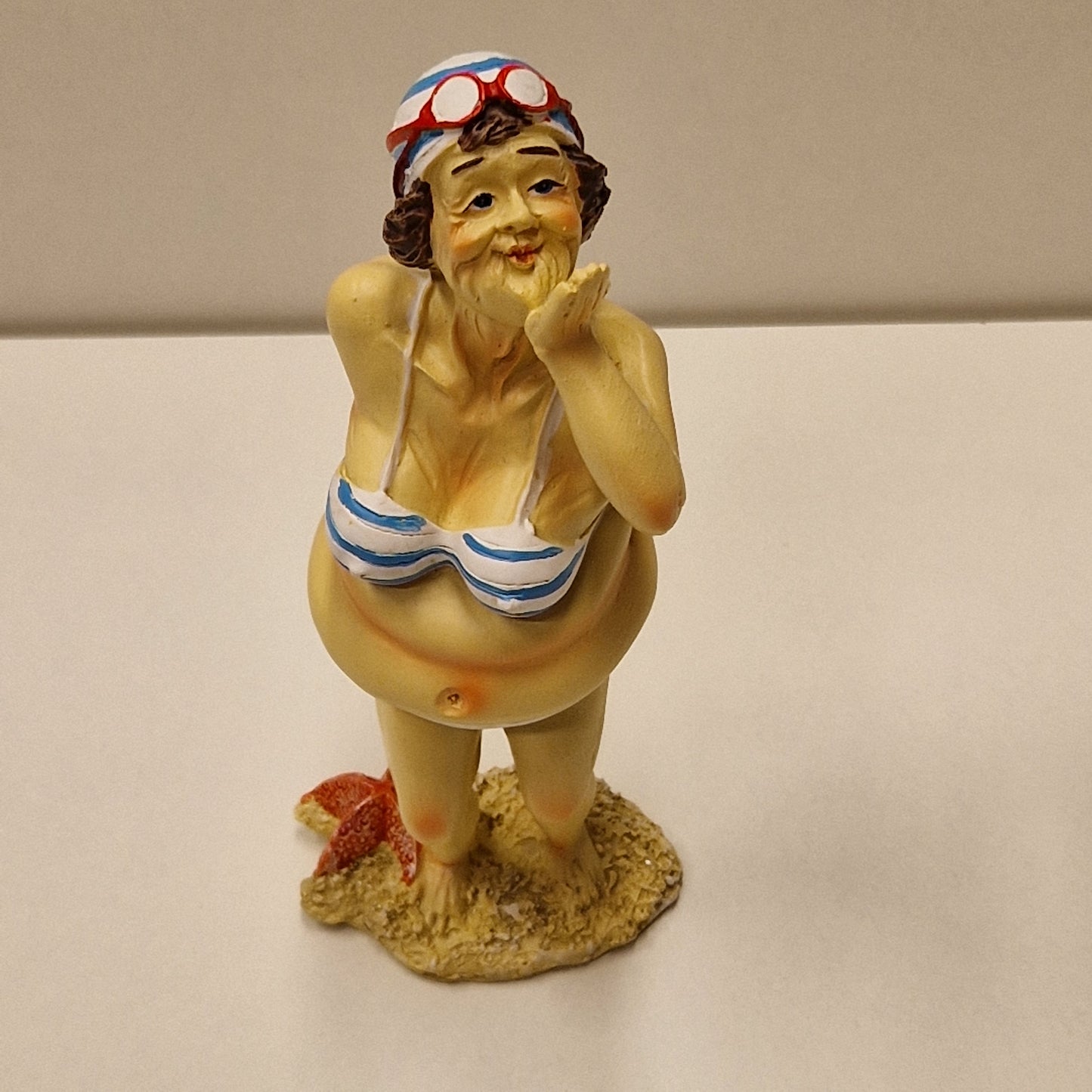 Sjarmerende eldre badedame i bikini som sender slengkyss