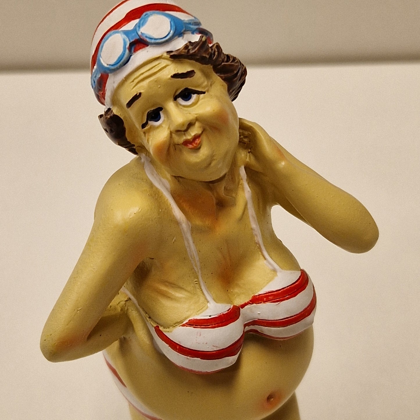 Sjarmerende eldre badedame i bikini med bedårende blikk